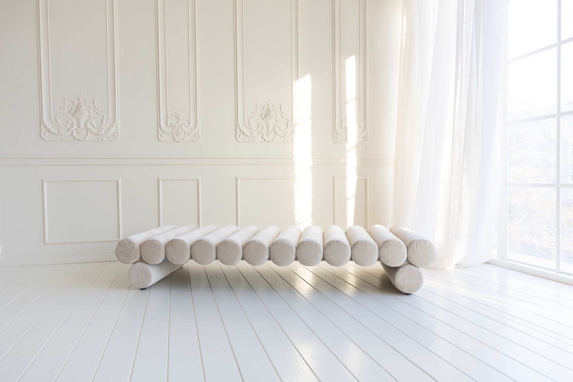 A light zone with plaster wall decorations and a tall window